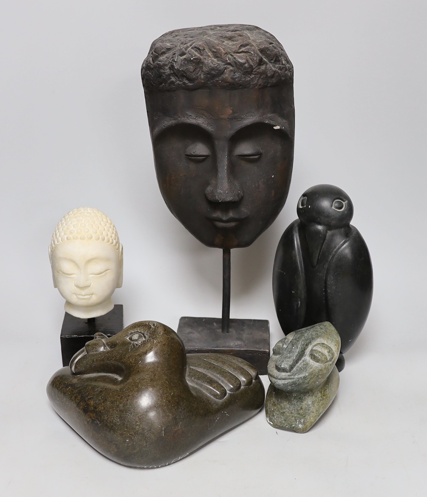 Three Inuit sculptures, a mask on stand and buddhist head, mask 39cms high